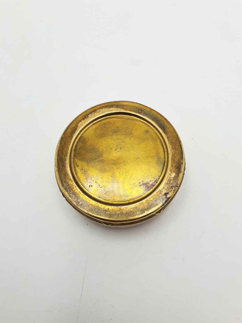 A small round brass trinket box featuring a detailed sculpted brass bear finial holding a stick on its lid. View III