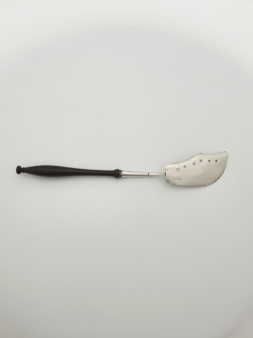 An antique silver sardine server featuring an engraved fish motif on a curved blade and a slender turned dark wooden handle. View VII