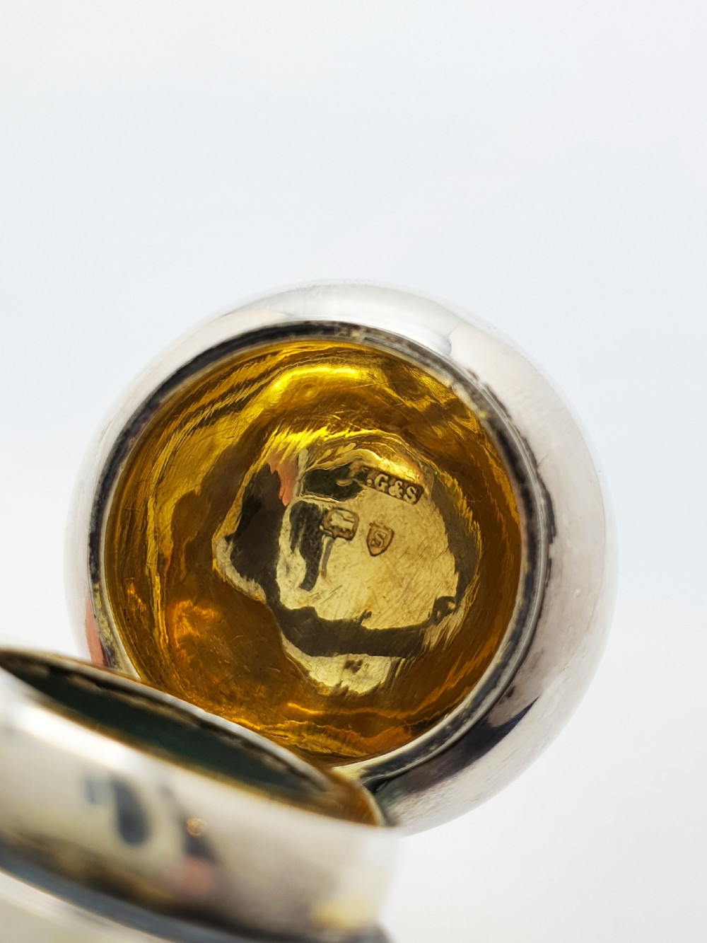 An antique round emerald green cut glass perfume bottle with a sterling silver domed top. View VII