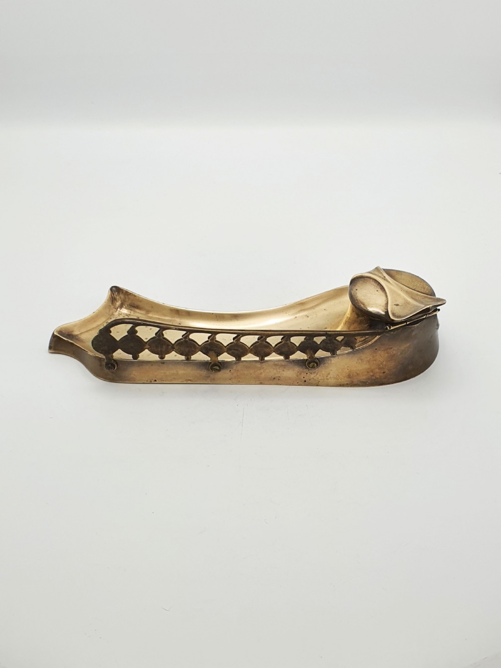 An Art Nouveau cast bronze inkwell featuring a hinged lid, organic curved pen rest tray, and decorative beaded back gallery. View VII