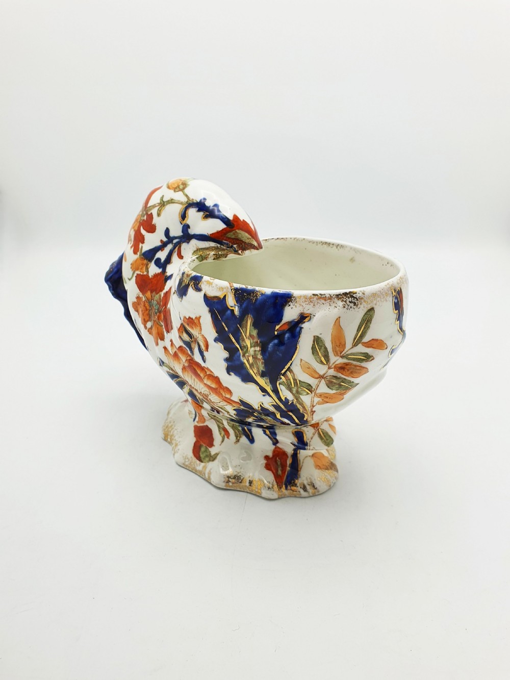 A late Victorian Ridgways china spoon warmer in the shape of a nautilus shell with cobalt blue, terracotta orange floral details, and gilded trim.