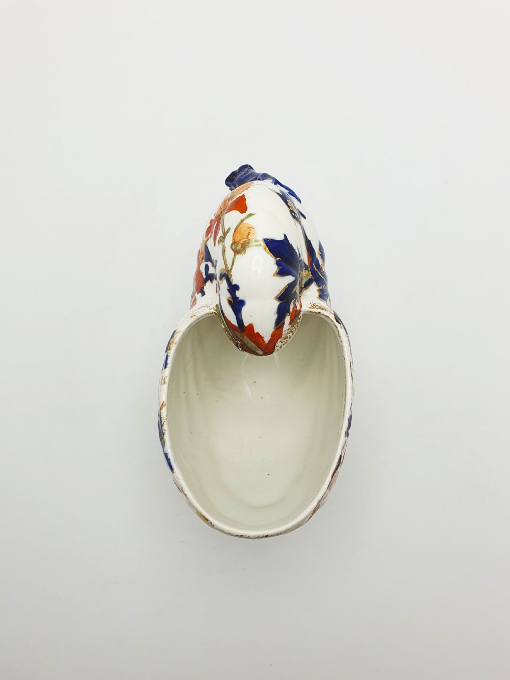 A late Victorian Ridgways china spoon warmer in the shape of a nautilus shell with cobalt blue, terracotta orange floral details, and gilded trim. View VII
