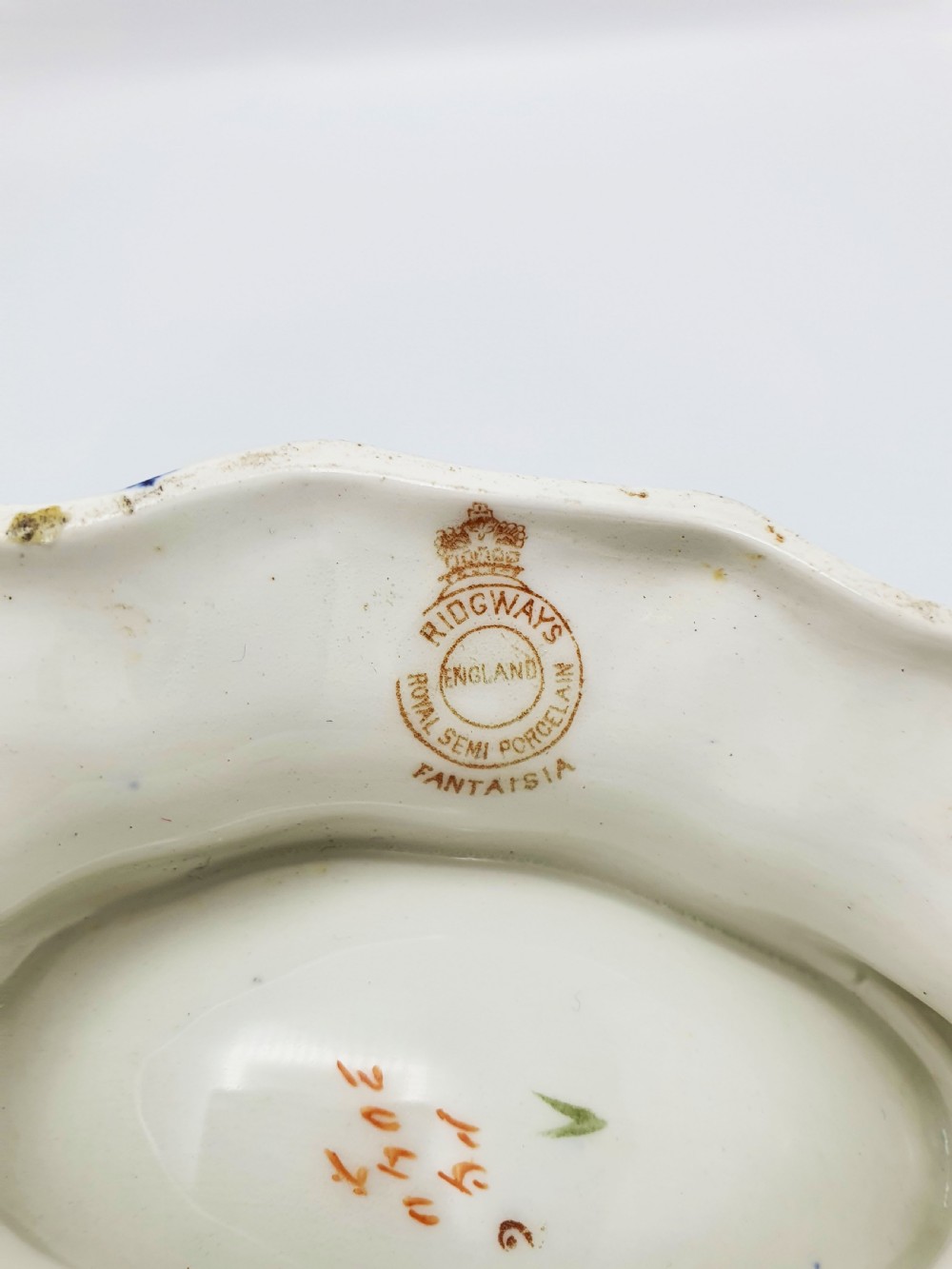 A late Victorian Ridgways china spoon warmer in the shape of a nautilus shell with cobalt blue, terracotta orange floral details, and gilded trim. View IX