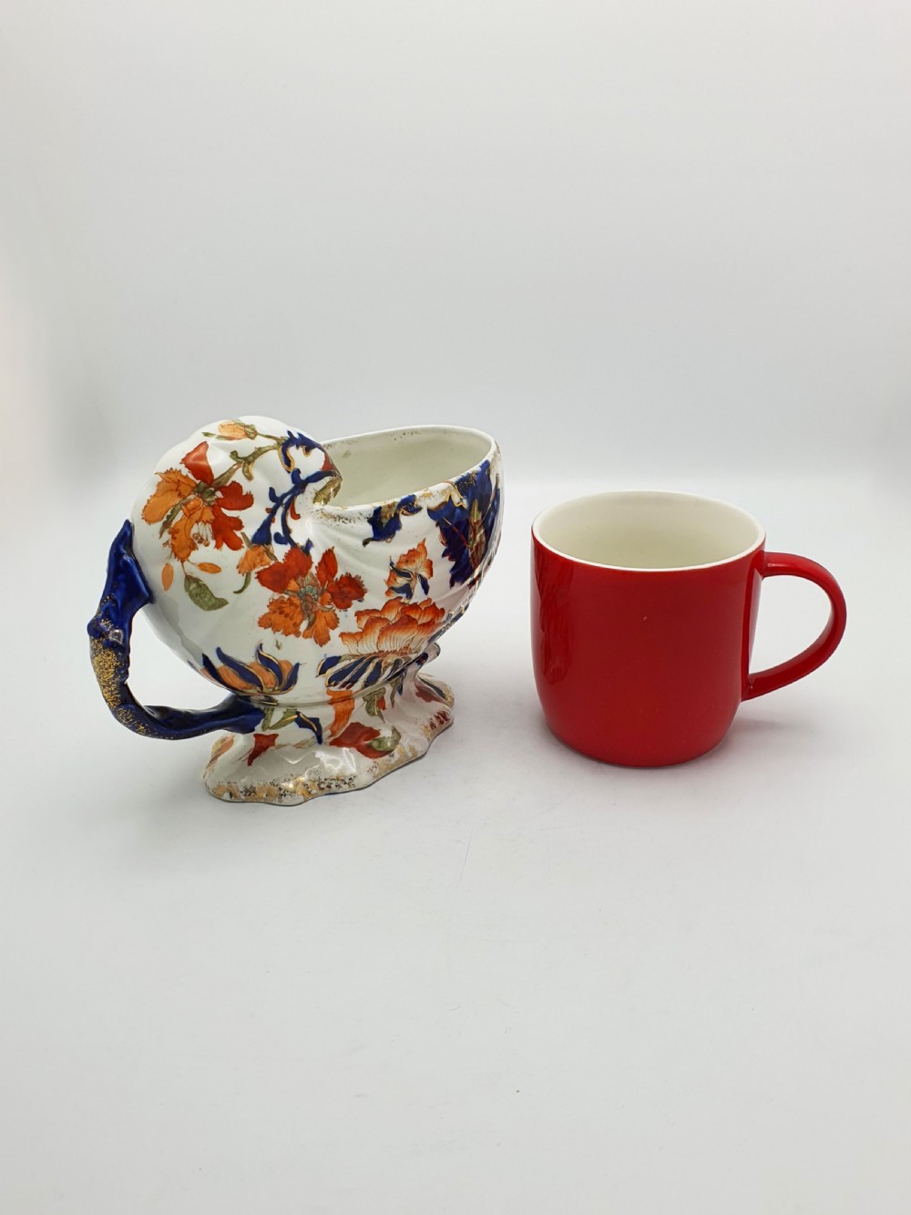A late Victorian Ridgways china spoon warmer in the shape of a nautilus shell with cobalt blue, terracotta orange floral details, and gilded trim. View X