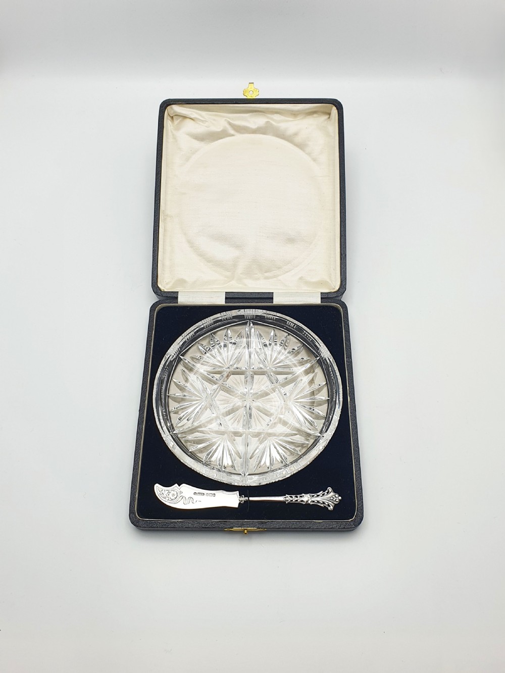 A circular cut crystal butter dish and a hallmarked sterling silver spreader presented inside a fitted black box. View II