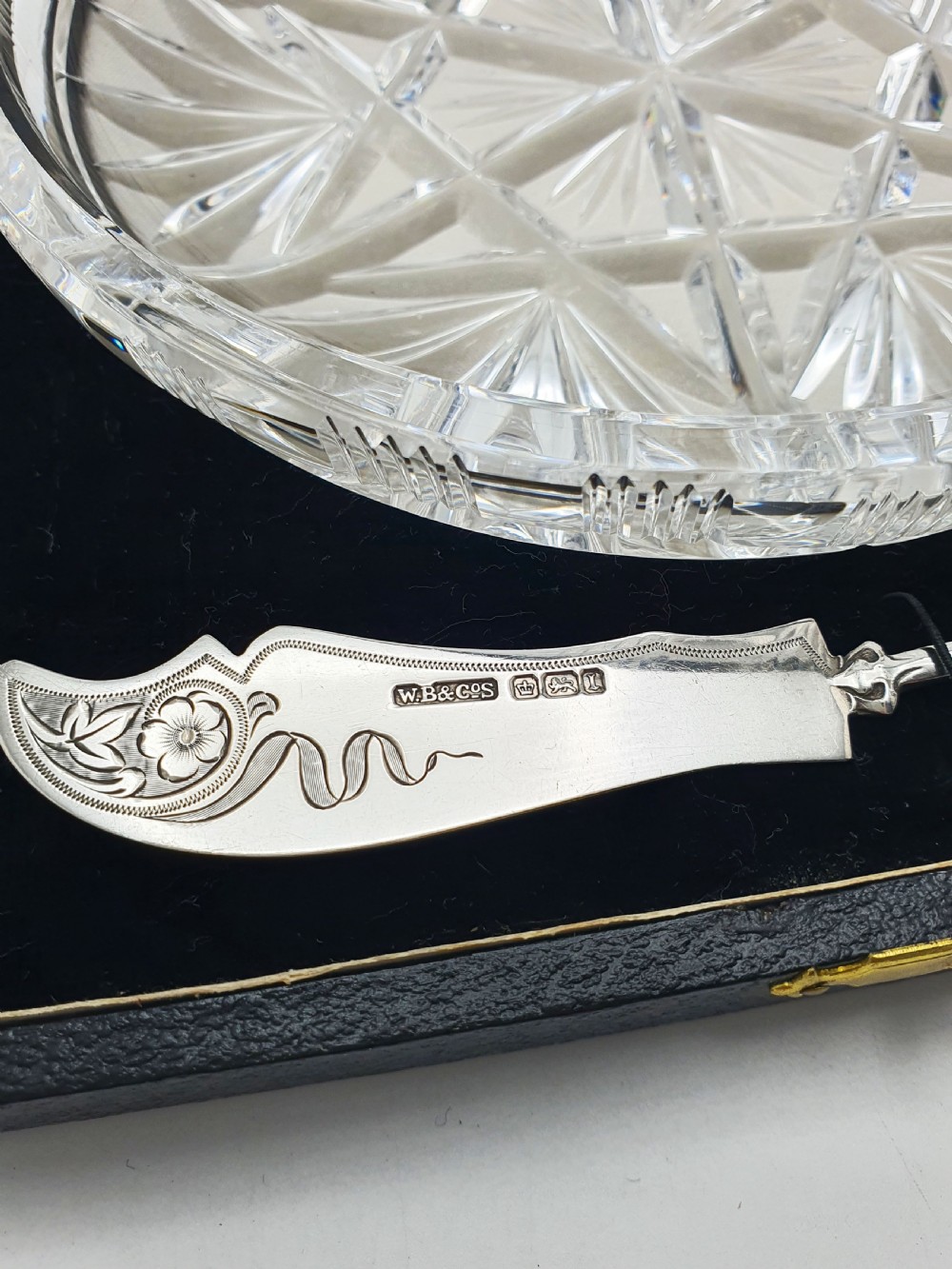 A circular cut crystal butter dish and a hallmarked sterling silver spreader presented inside a fitted black box. View III