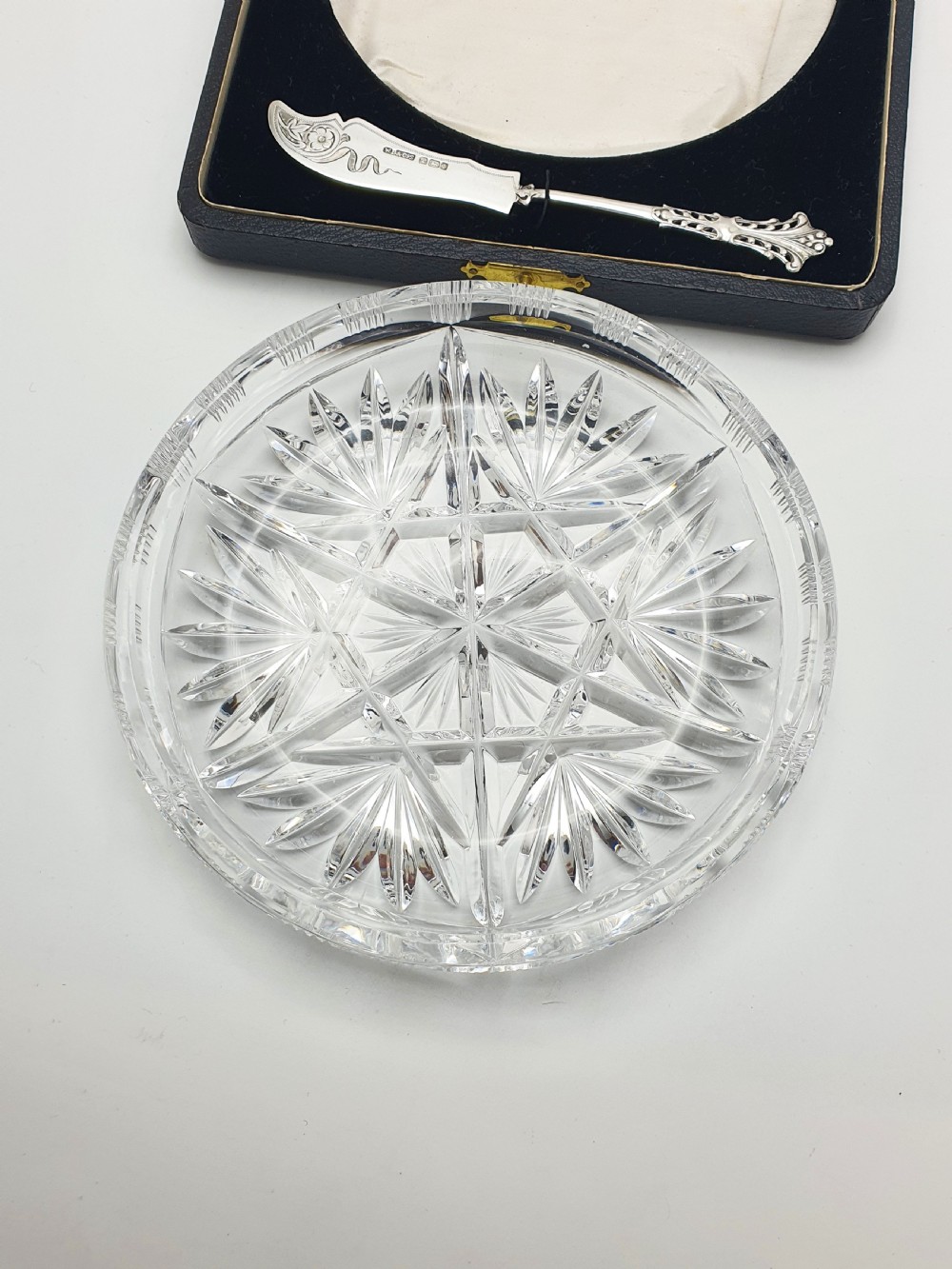 A circular cut crystal butter dish and a hallmarked sterling silver spreader presented inside a fitted black box. View VI
