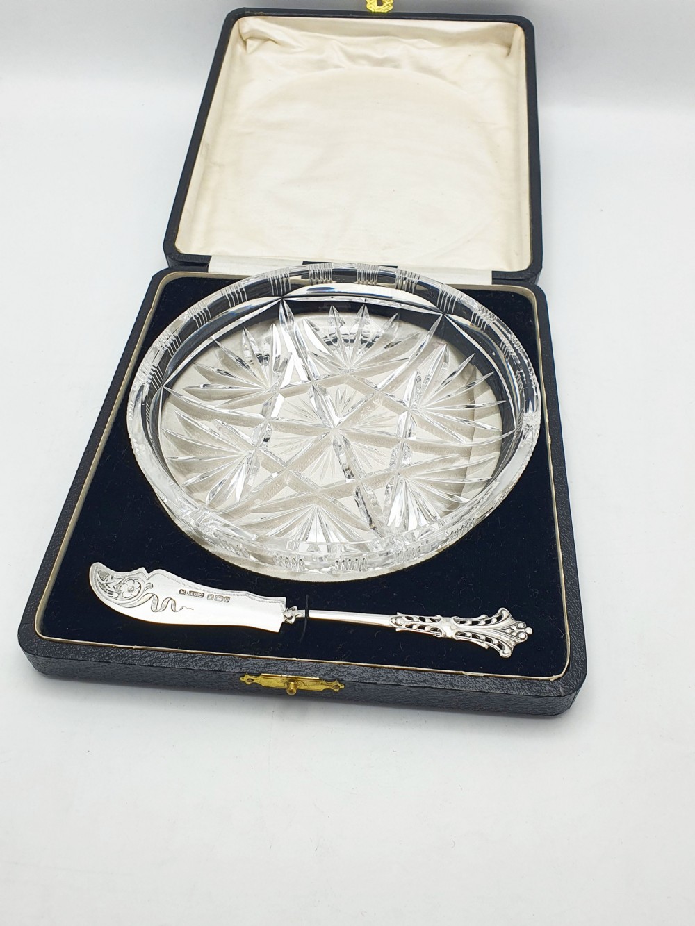 A circular cut crystal butter dish and a hallmarked sterling silver spreader presented inside a fitted black box. View VIII