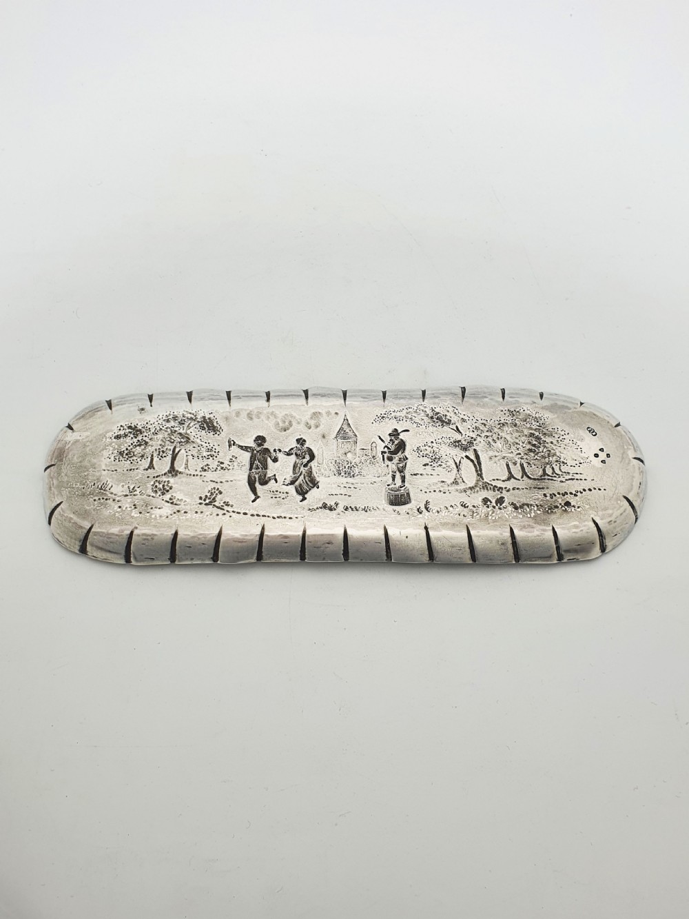 An elongated Victorian sterling silver tray featuring an embossed scene of a dancing couple and a musician surrounded by a fluted border. View IV