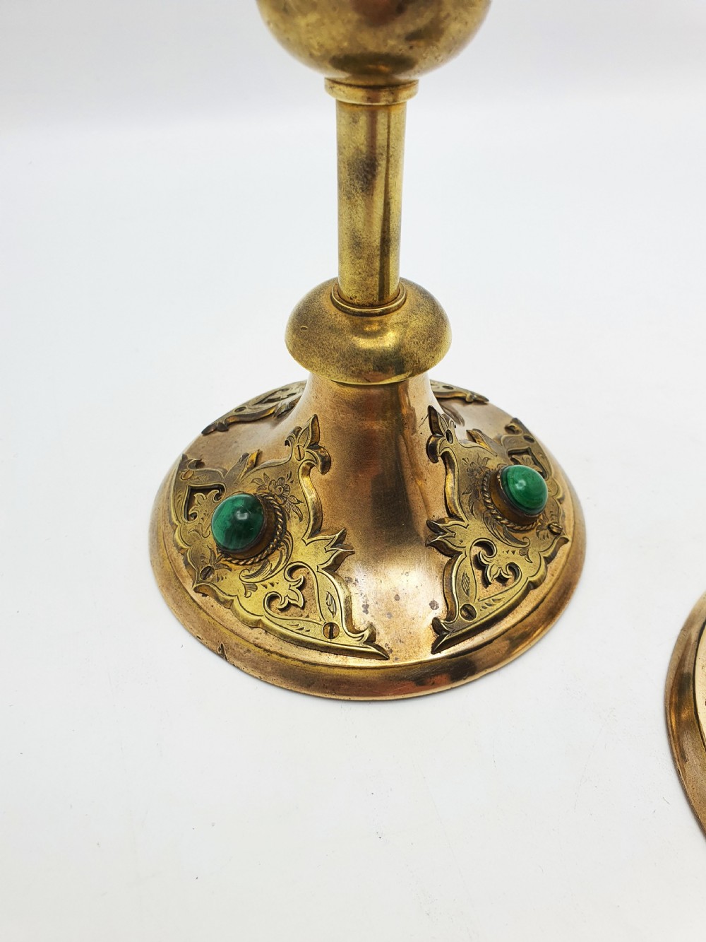 A pair of Victorian Gothic Revival brass candlesticks featuring spiral stems, spherical central knops, and circular bases with inset green cabochon stones. View III