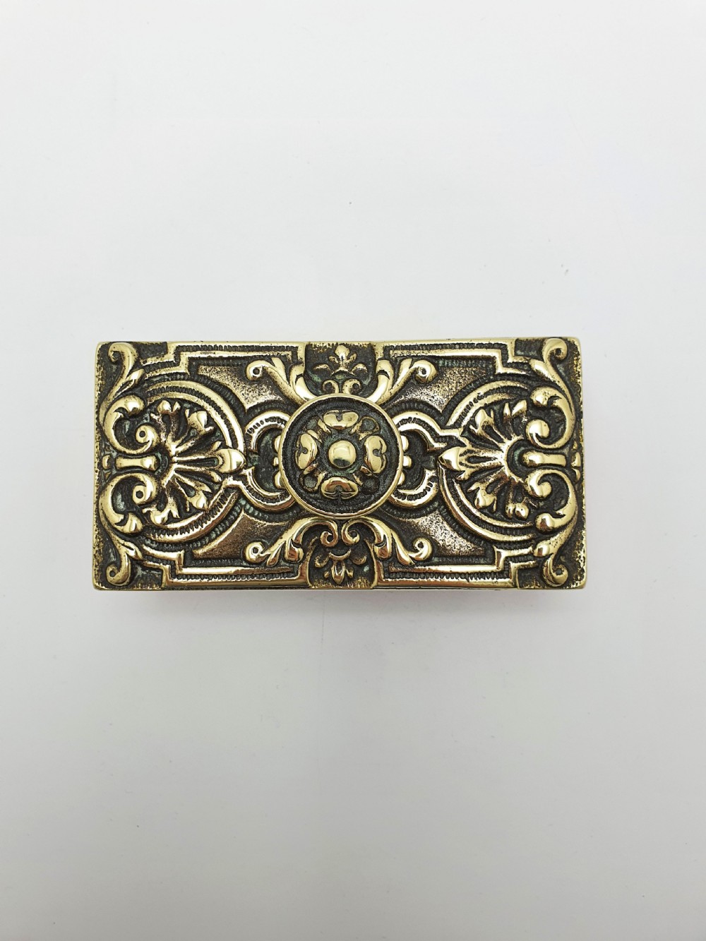 An Edwardian brass and wood rocker ink blotter featuring an ornate cast brass top plate decorated with relief scrollwork and a central turned brass knob handle. View VII