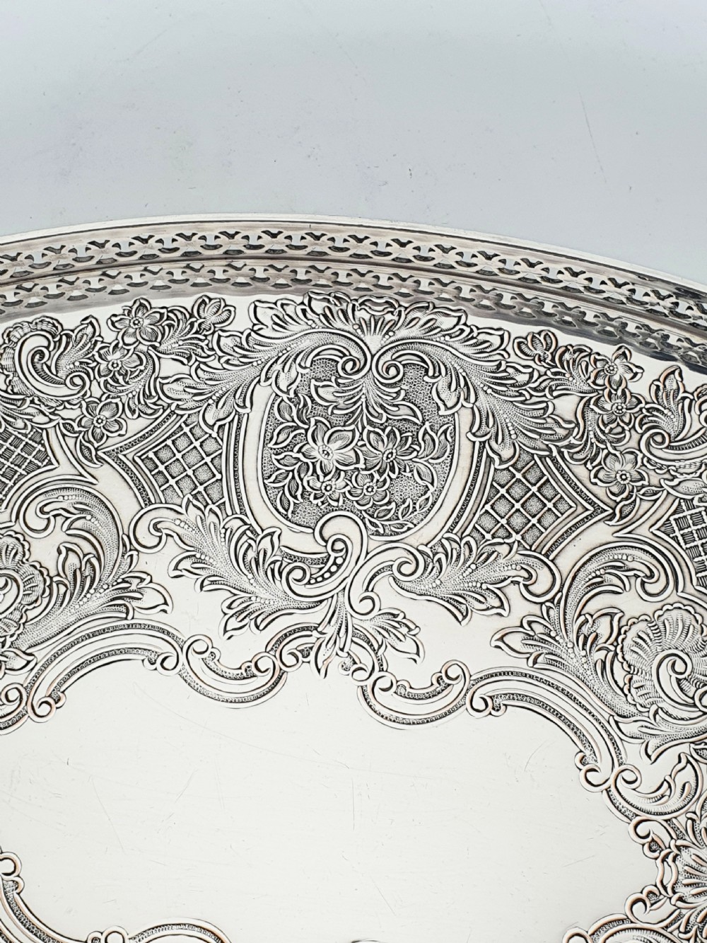 An oval silver-plated serving tray featuring a pierced gallery rim and an engraved surface with scroll motifs around a plain central cartouche. View III