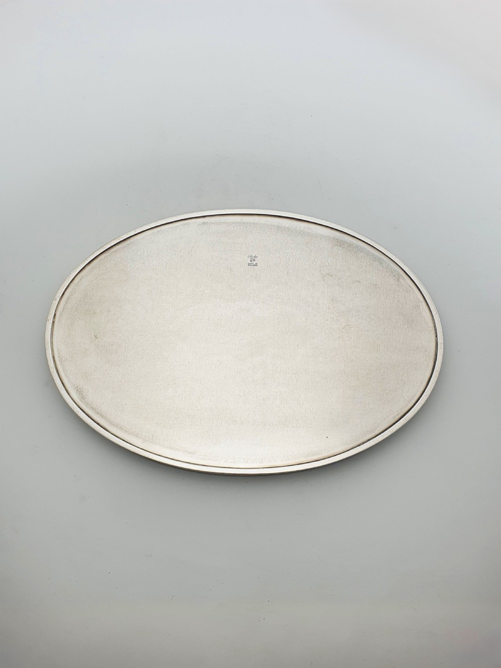 An oval silver-plated serving tray featuring a pierced gallery rim and an engraved surface with scroll motifs around a plain central cartouche. View V