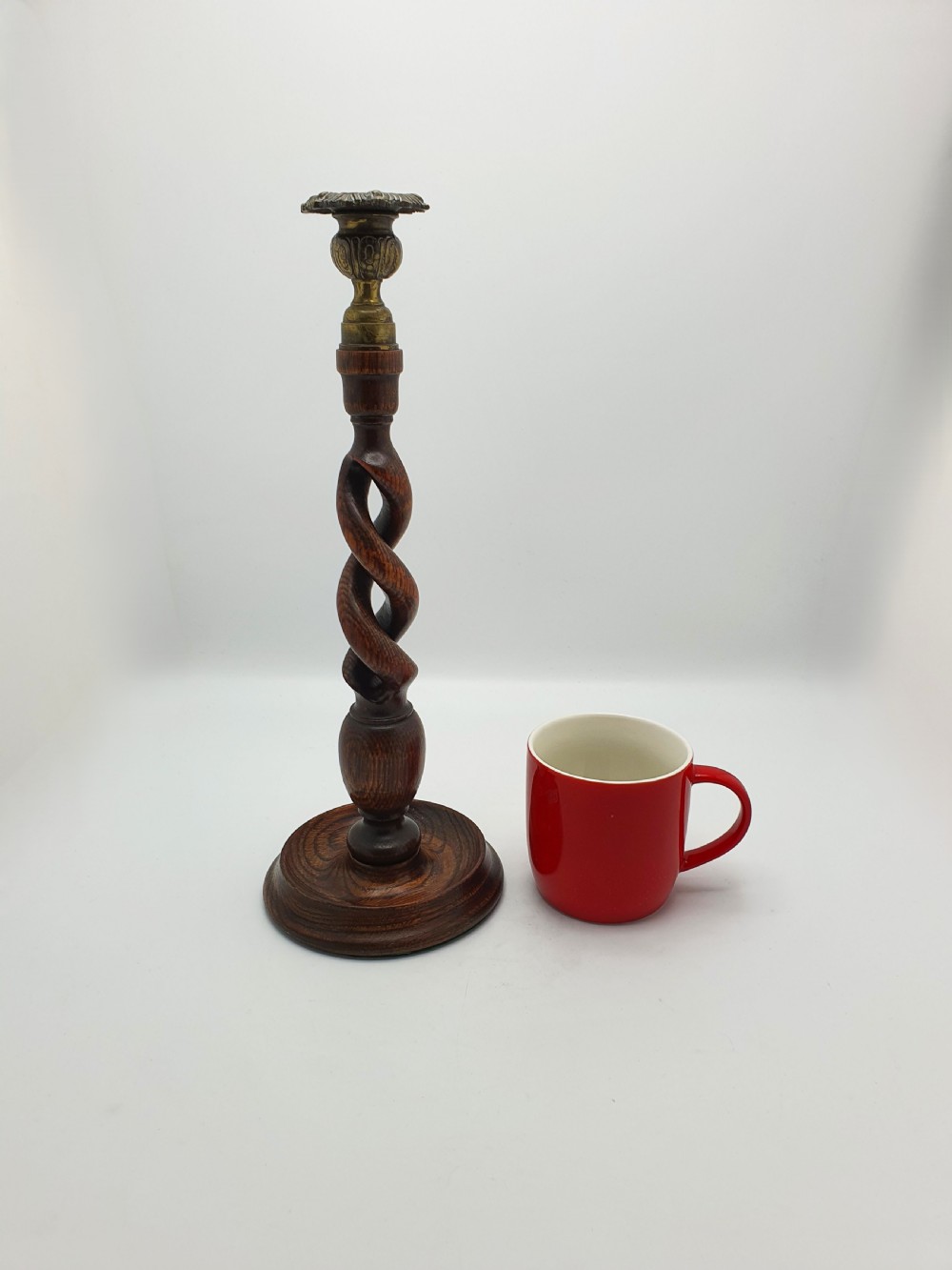 A pair of dark oak candlesticks featuring open barley twist shafts, circular stepped bases, and metal brass sconces. View XIII