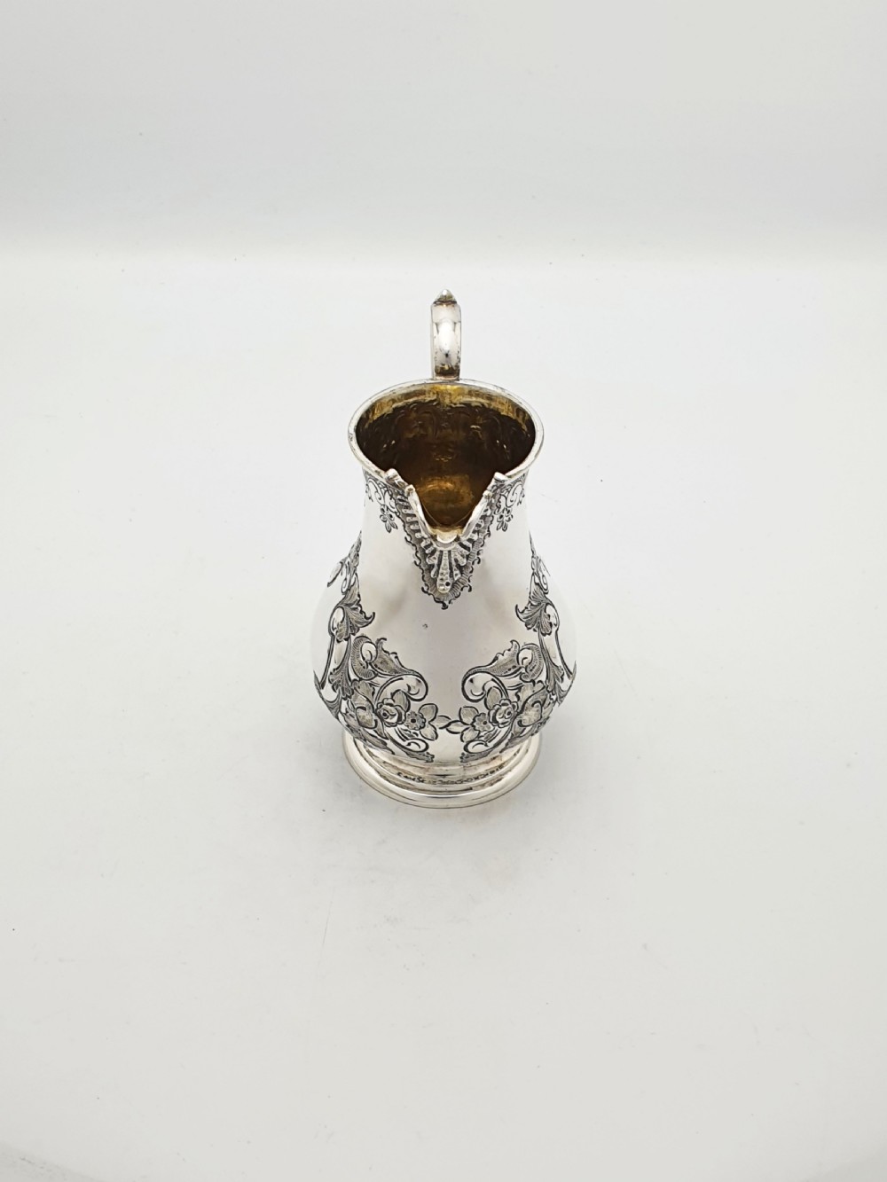 A two-piece Victorian silver-plated set featuring a milk jug and a double-handled sugar bowl, both decorated with intricate repousse floral scrollwork and lined with a gilded interior. View IX