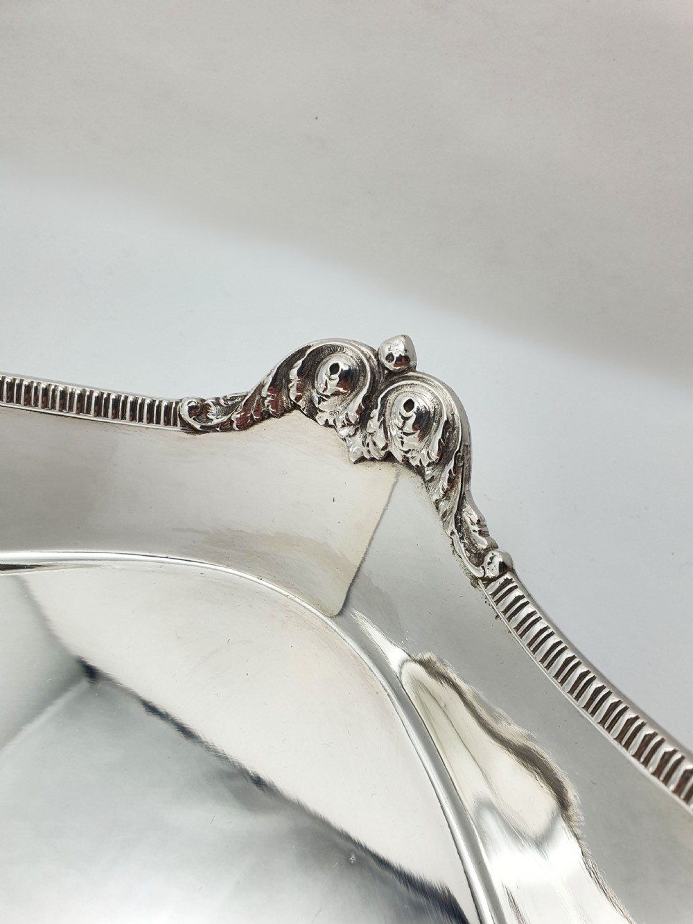 An Edwardian rectangular silver-plated serving tray featuring raised sides, integral hand-holds, and decorative shell and scroll details along the rim. View II