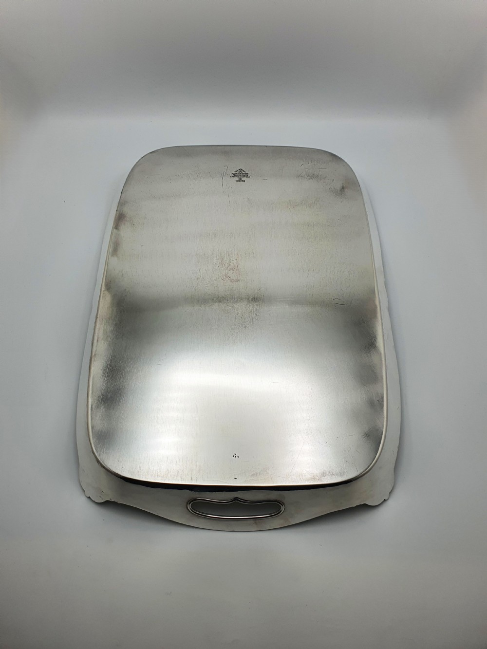 An Edwardian rectangular silver-plated serving tray featuring raised sides, integral hand-holds, and decorative shell and scroll details along the rim. View VIII