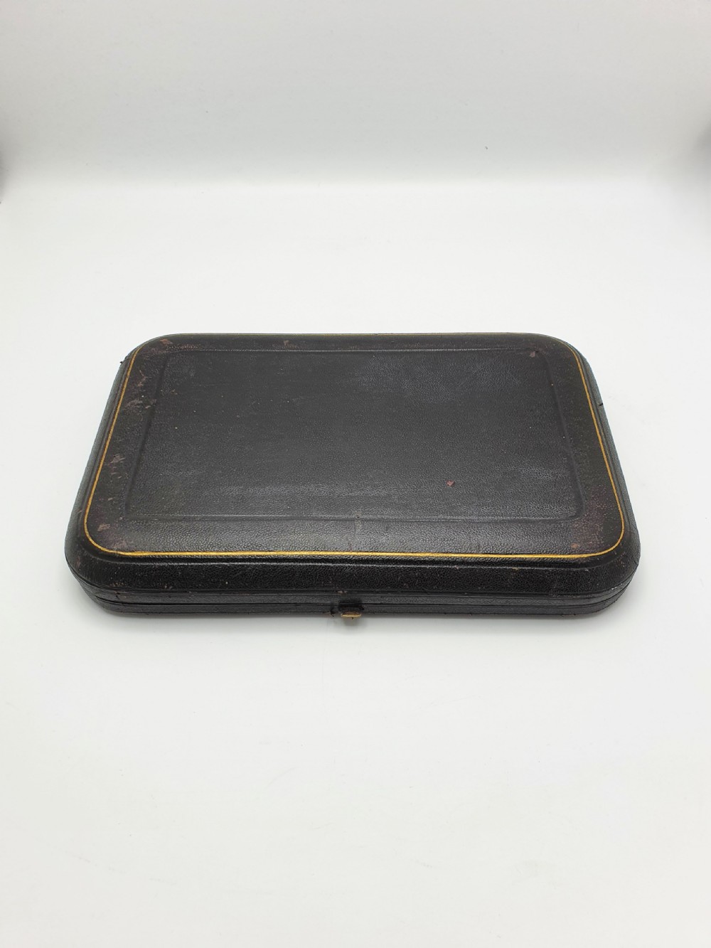 An open black presentation box lined with magenta velvet containing two engraved silver serving spoons and matching grape shears. View VIII