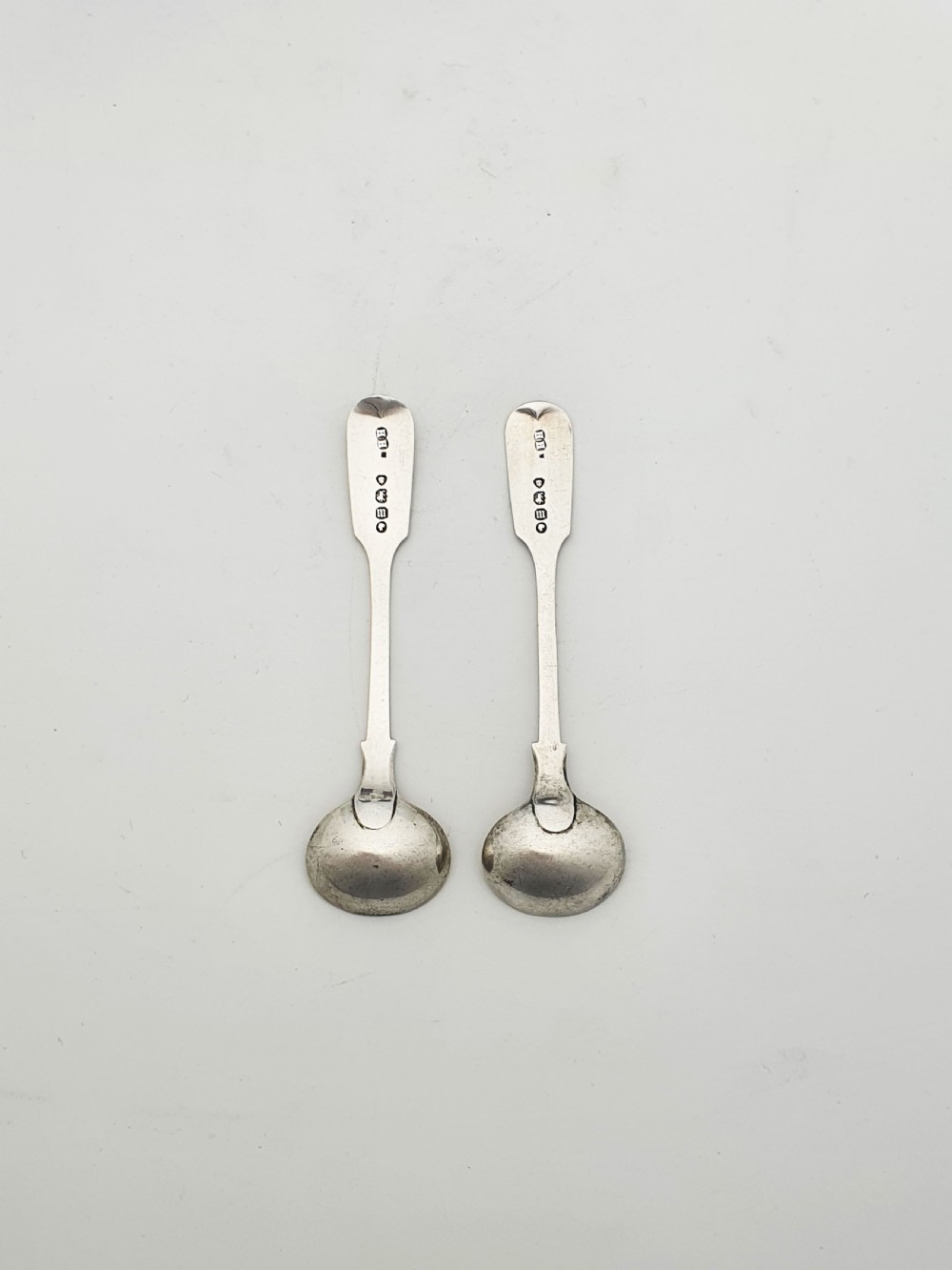 A pair of circular pierced sterling silver salt cellars containing dark cobalt blue glass liners with accompanying engraved silver spoons. View XV