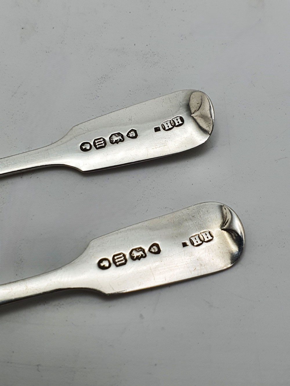 A pair of circular pierced sterling silver salt cellars containing dark cobalt blue glass liners with accompanying engraved silver spoons. View XVI