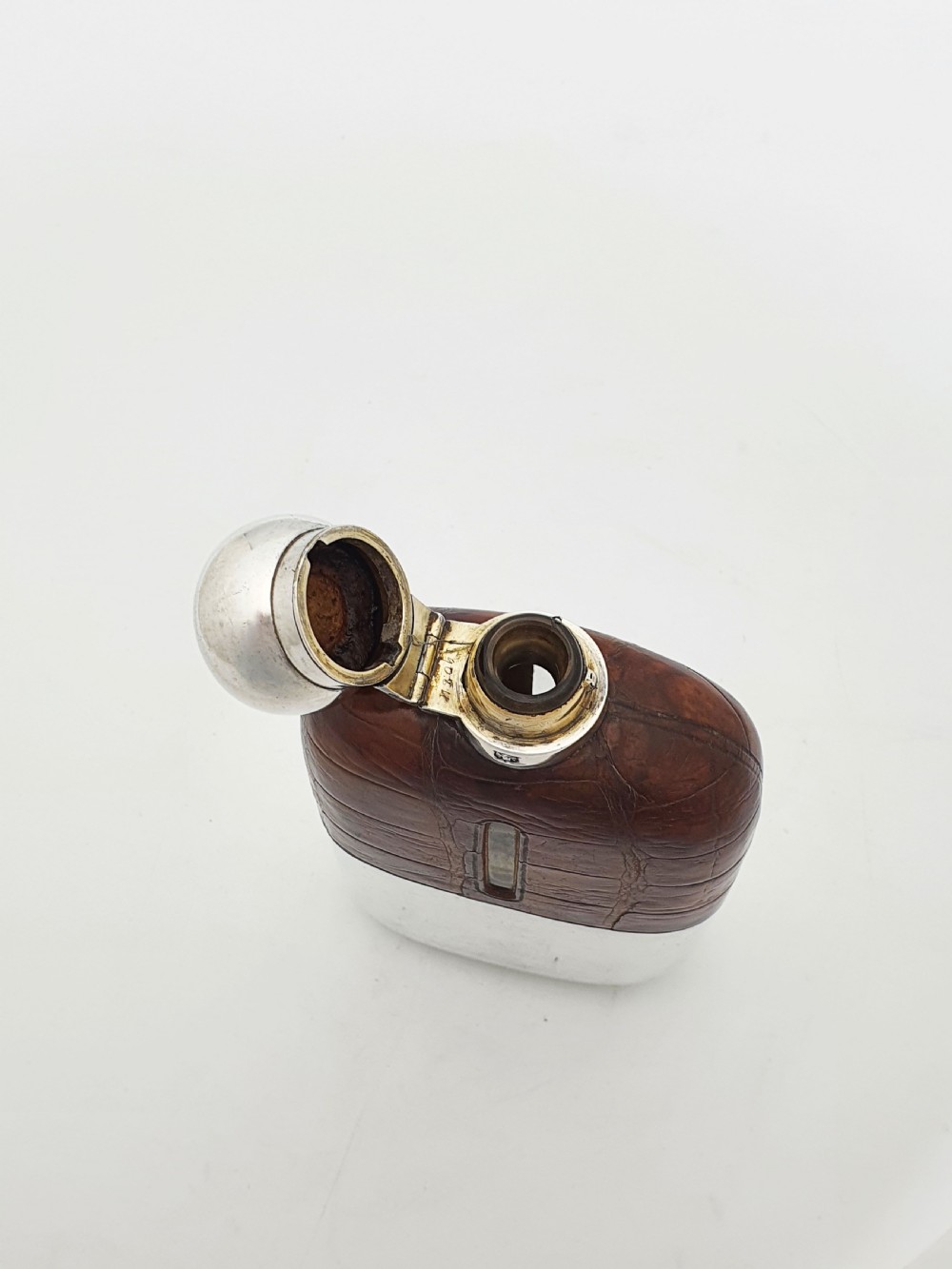 An antique Edwardian hip flask featuring a brown crocodile skin upper section with a vertical sight slot and a silver-plated lower removable cup. View IV