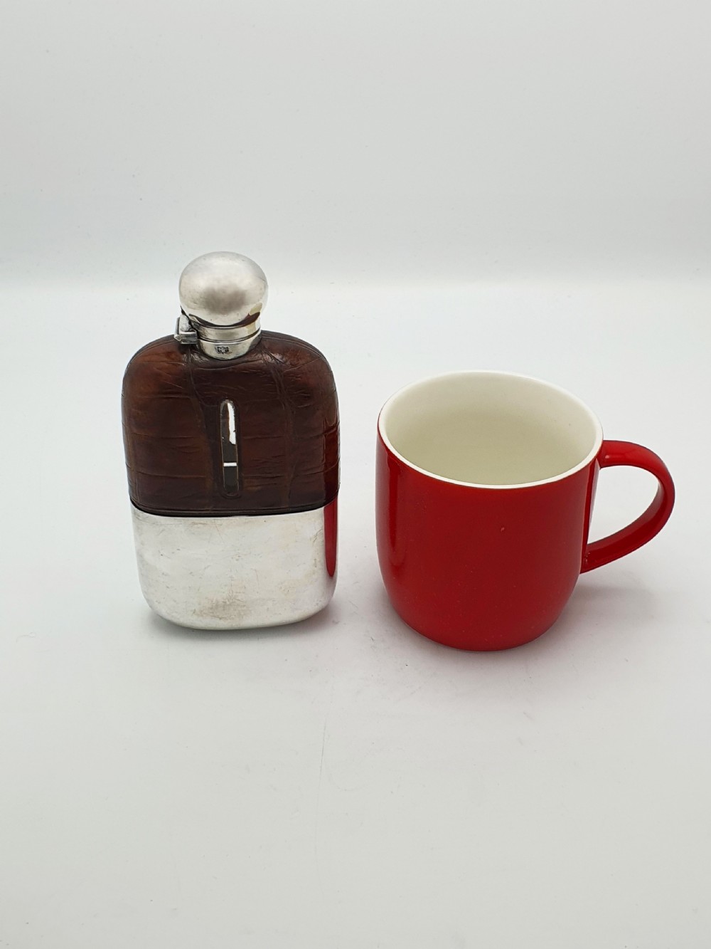 An antique Edwardian hip flask featuring a brown crocodile skin upper section with a vertical sight slot and a silver-plated lower removable cup. View IX
