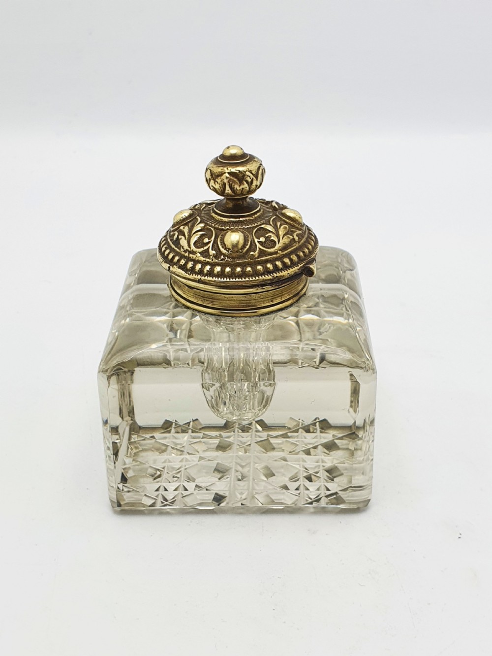 A square, heavy cut-glass antique inkwell featuring a diamond pattern and an ornate, embossed brass hinged lid. View VI
