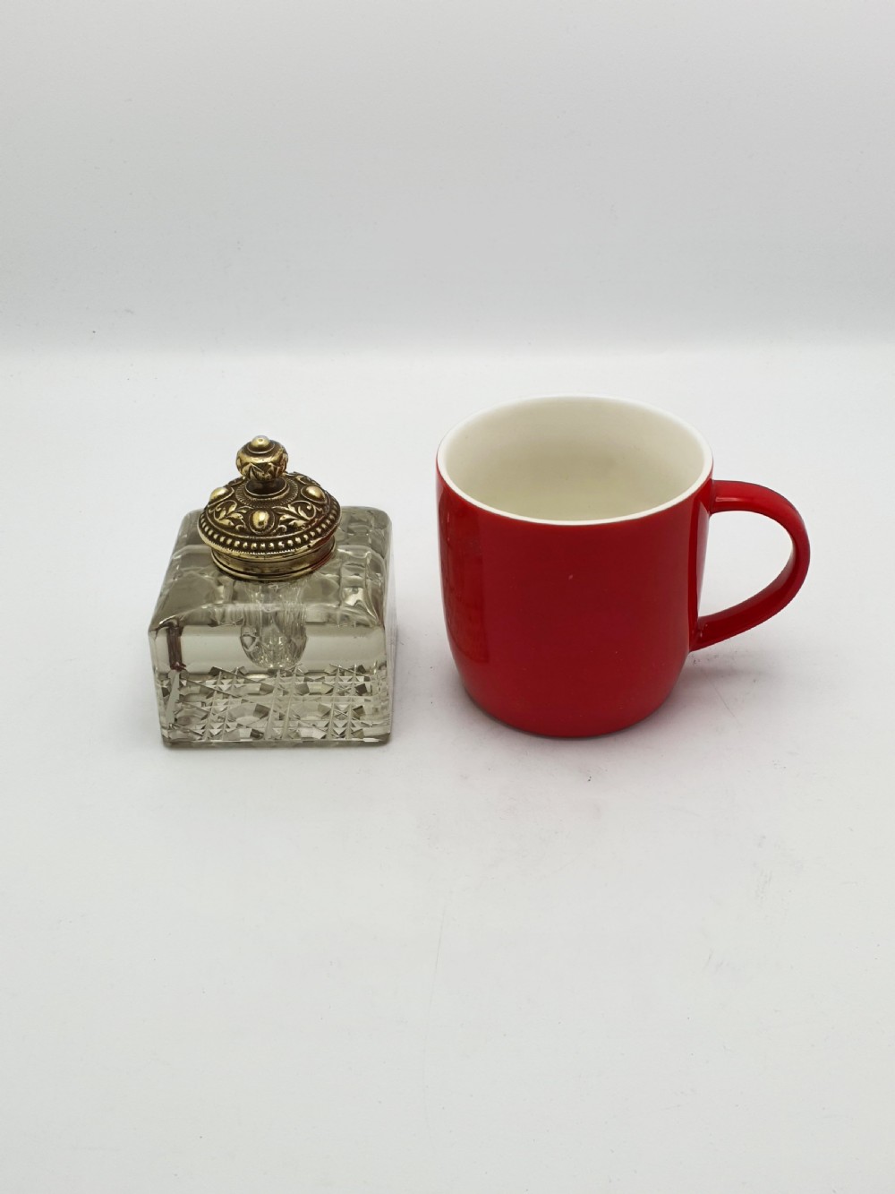 A square, heavy cut-glass antique inkwell featuring a diamond pattern and an ornate, embossed brass hinged lid. View X