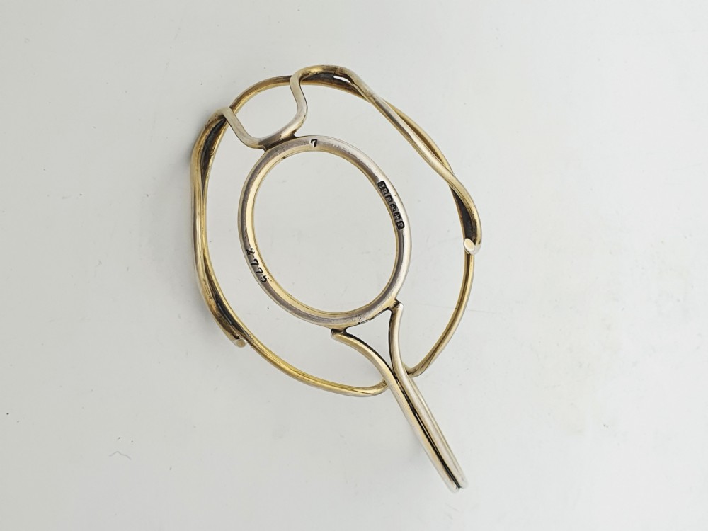 A late Victorian walnut-shaped metal condiment container featuring a textured silver lid and a brass lower shell resting within a wirework stand with a handle. View XI