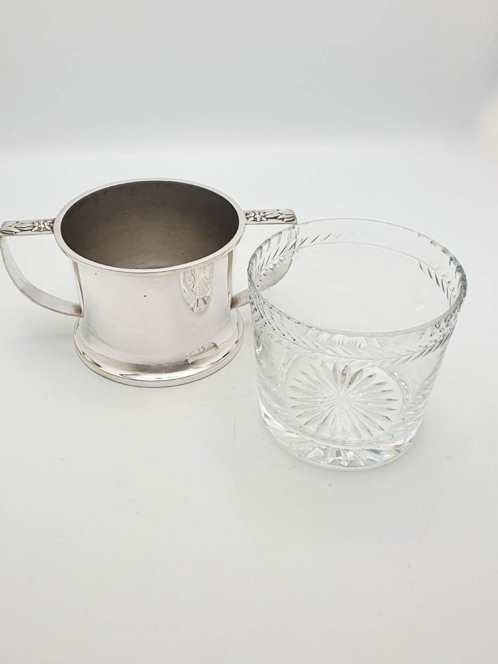An Art Deco silver-plated ice bucket featuring twin handles, a removable cut-glass liner with a leaf pattern, and matching ice tongs. View VII