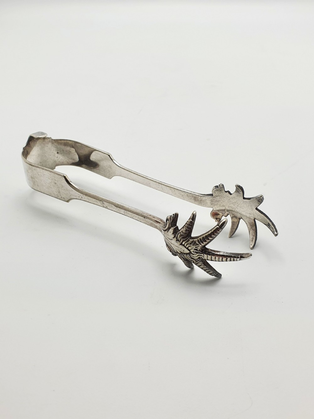An Art Deco silver-plated ice bucket featuring twin handles, a removable cut-glass liner with a leaf pattern, and matching ice tongs. View VIII