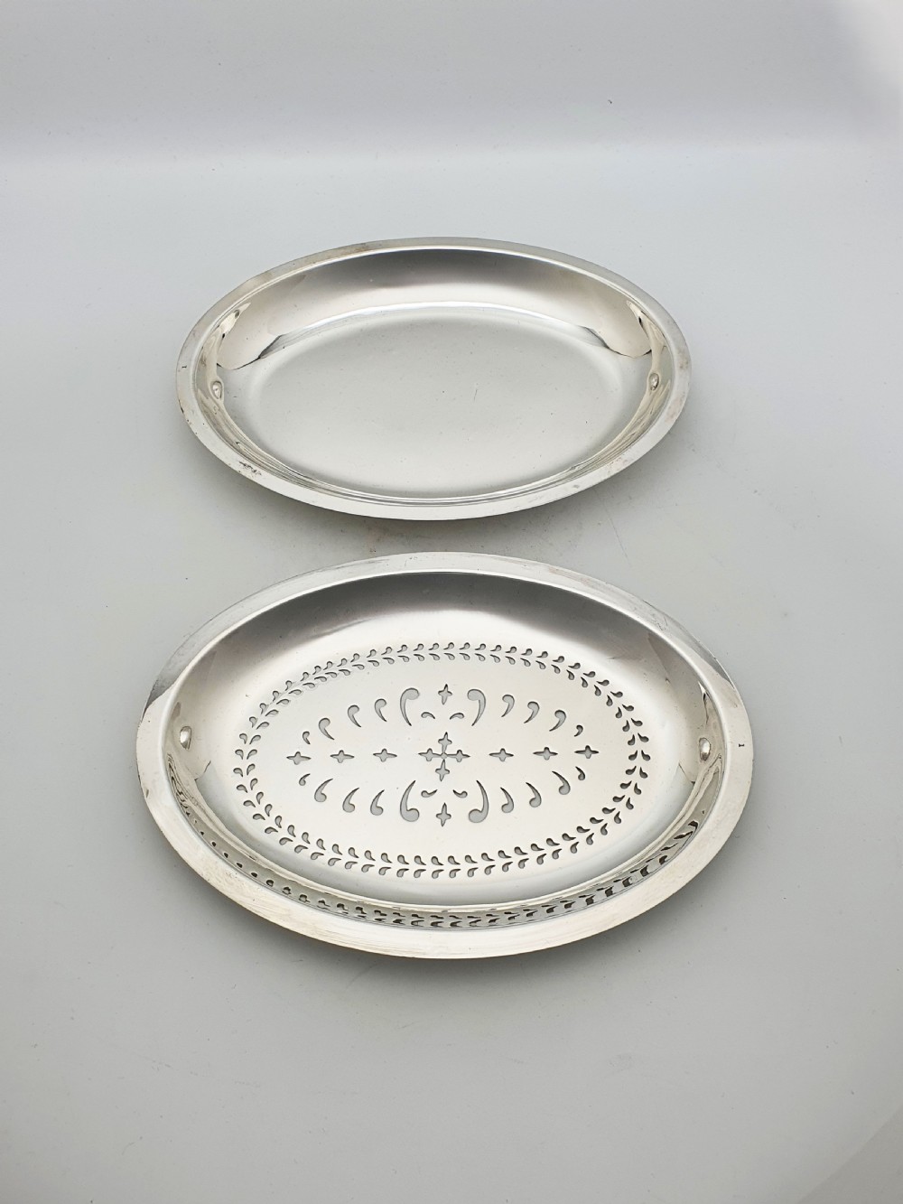 A late Victorian oval silver-plated rollover dish featuring bright-cut botanical engravings, a beaded rim, and side pivot handles. View VIII