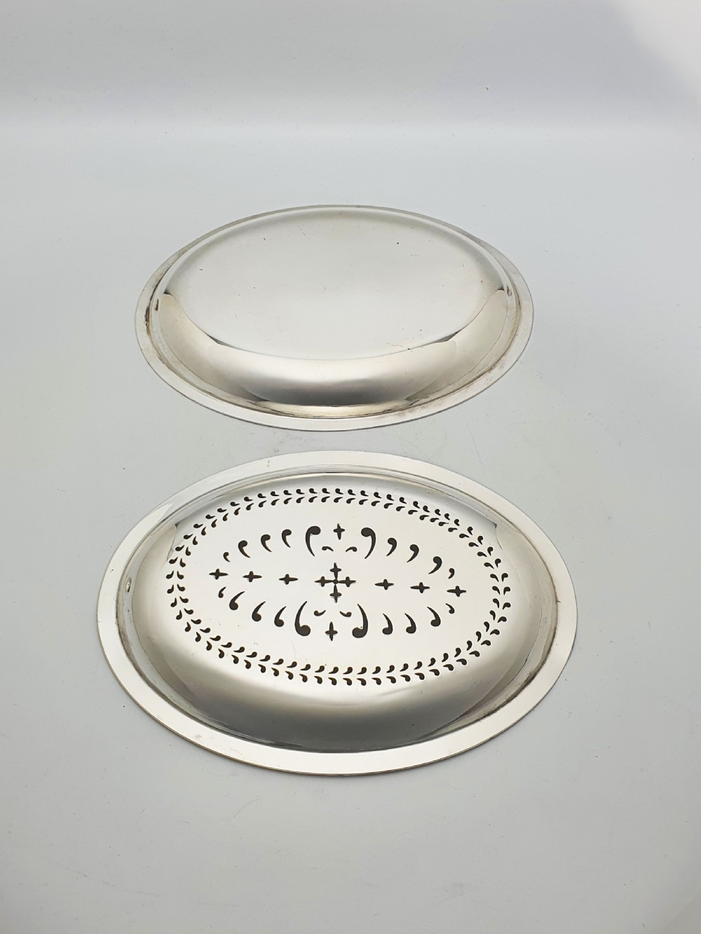 A late Victorian oval silver-plated rollover dish featuring bright-cut botanical engravings, a beaded rim, and side pivot handles. View IX