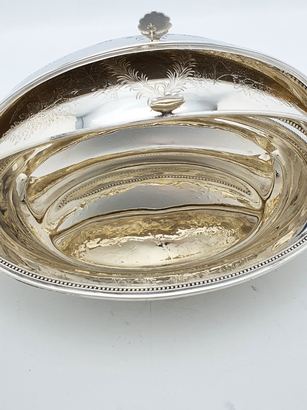 A late Victorian oval silver-plated rollover dish featuring bright-cut botanical engravings, a beaded rim, and side pivot handles. View XI