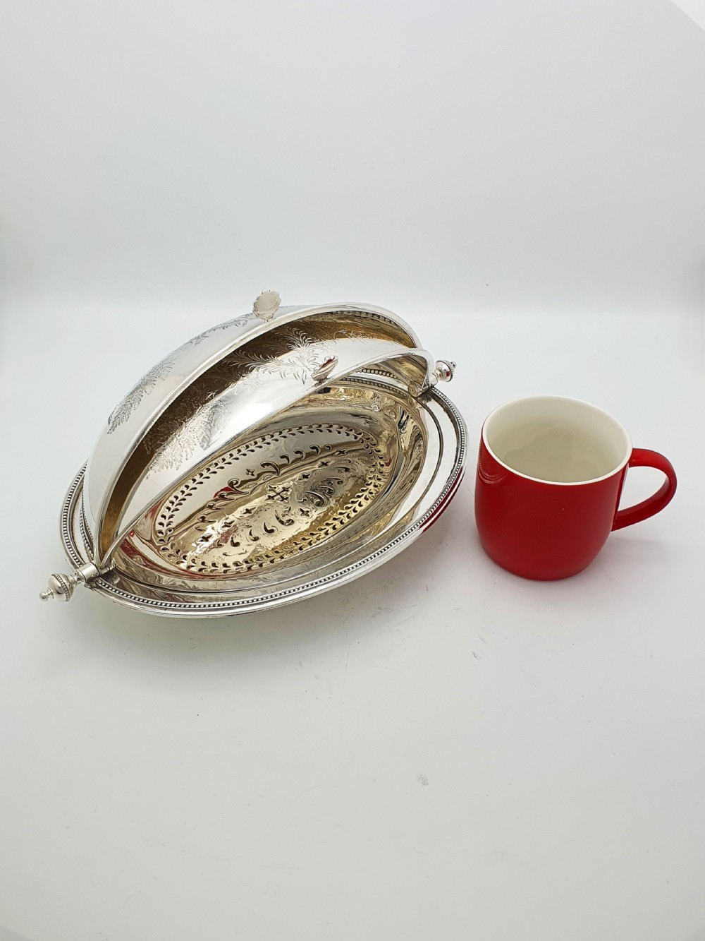 A late Victorian oval silver-plated rollover dish featuring bright-cut botanical engravings, a beaded rim, and side pivot handles. View XIV