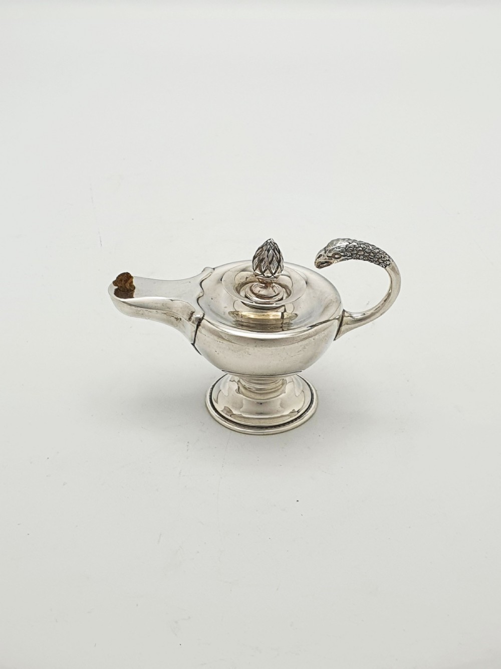 A sterling silver table lighter crafted in the shape of a classical Roman oil lamp with a serpent-shaped handle and pedestal foot. View IV