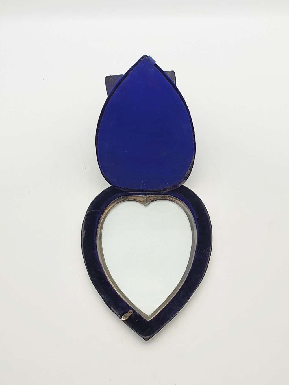 A heart-shaped Edwardian sterling silver picture frame with a smooth polished finish and dark blue display interior. View VI