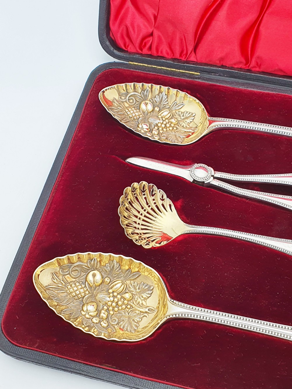 A Victorian silver-plated fruit serving set with embossed gilt bowls and grape shears, displayed inside a red velvet-lined presentation box. View III