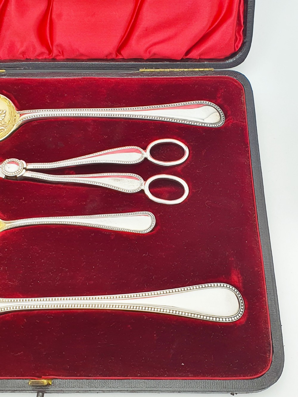 A Victorian silver-plated fruit serving set with embossed gilt bowls and grape shears, displayed inside a red velvet-lined presentation box. View IV