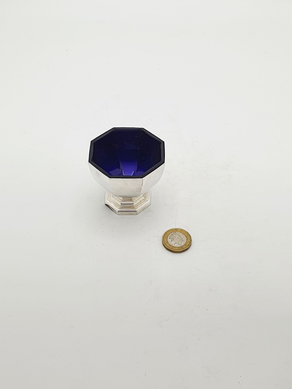 A set of four octagonal silver-plated salt cellars featuring dark cobalt blue glass liners on stepped pedestal bases. View XIII