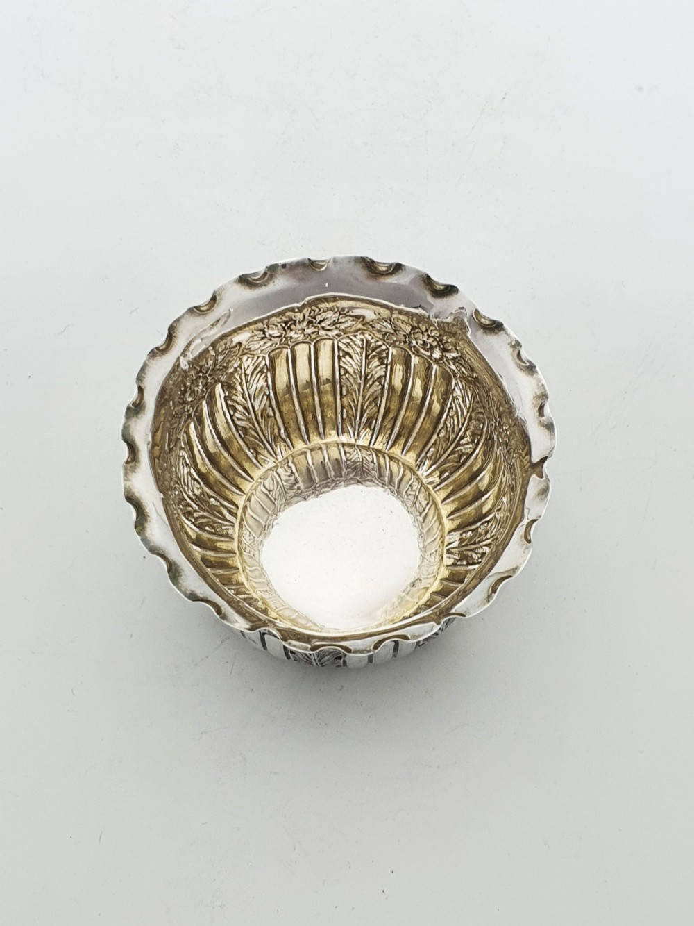 A small Late Victorian sterling silver bowl featuring fluted leaf decoration, floral engraving, a crimped rim, and a gilded interior. View II
