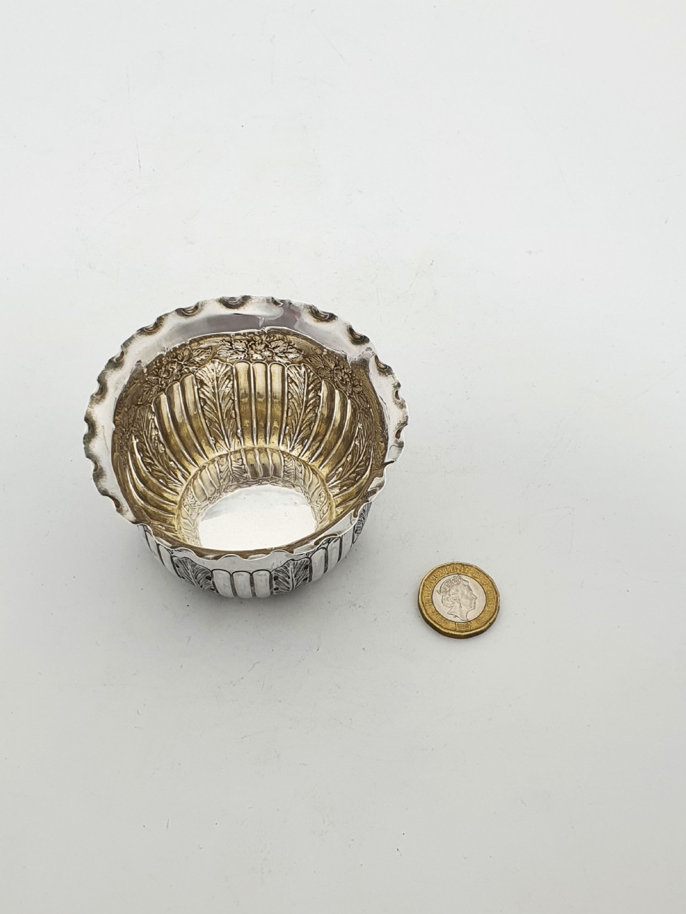 A small Late Victorian sterling silver bowl featuring fluted leaf decoration, floral engraving, a crimped rim, and a gilded interior. View VI