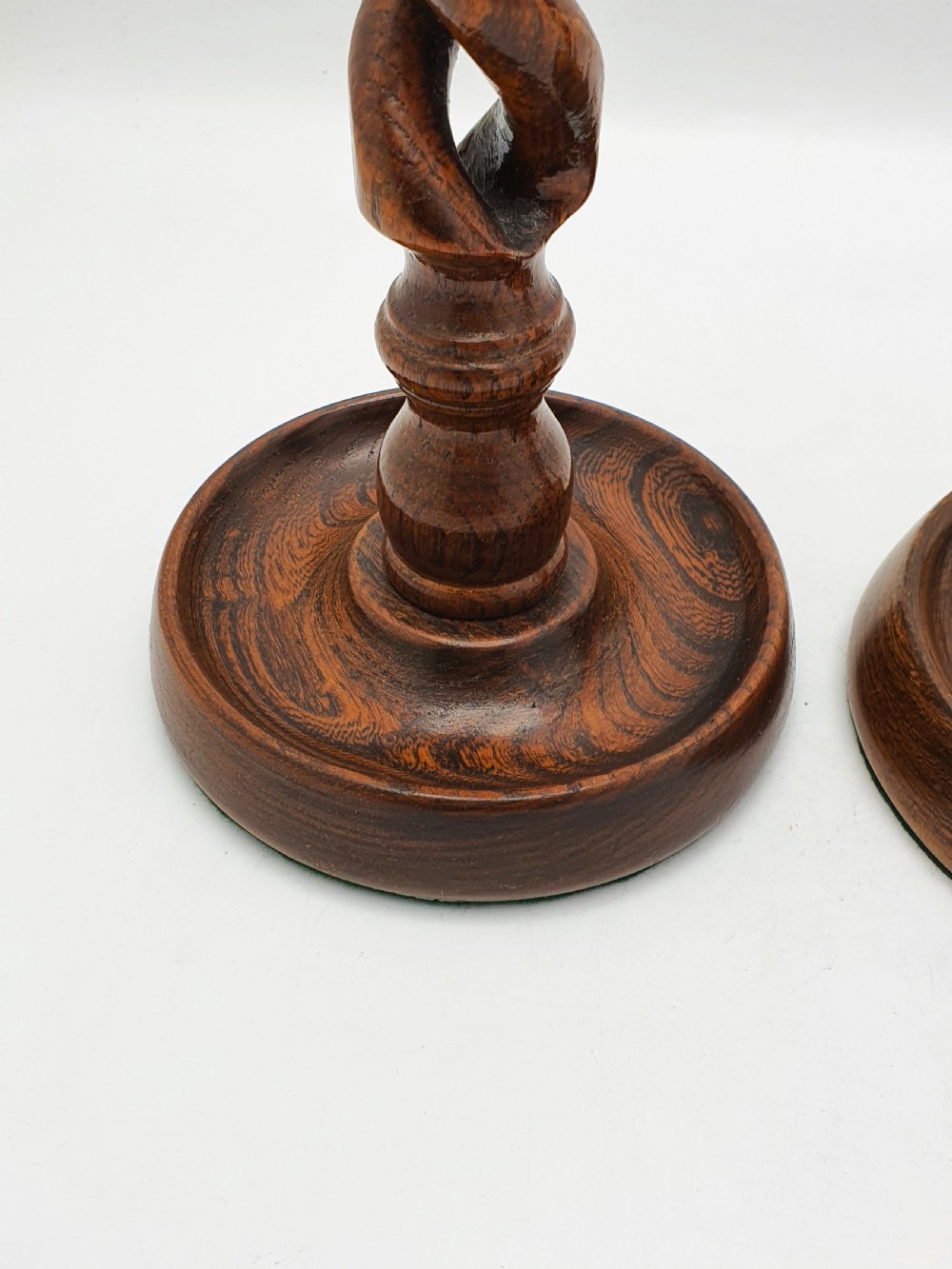 A pair of dark oak candlesticks featuring open barley twist stems and brass sconces atop round dished bases. View II