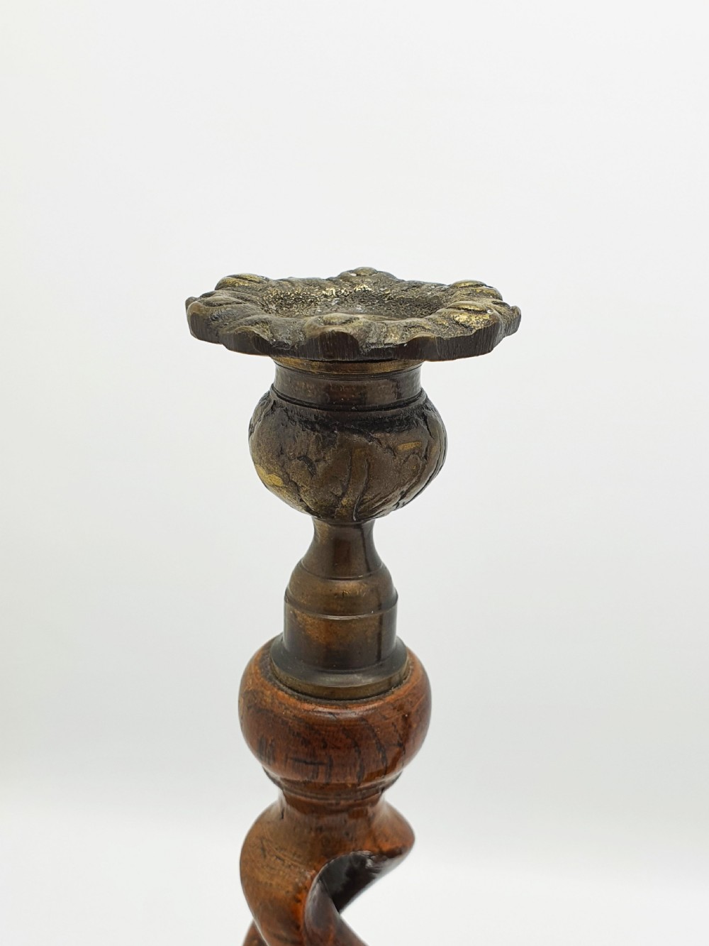 A pair of dark oak candlesticks featuring open barley twist stems and brass sconces atop round dished bases. View IV