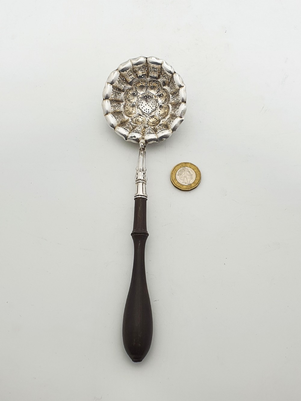 A late nineteenth-century Continental silver tea strainer featuring a fluted pierced bowl attached to a dark turned wooden handle. View VIII