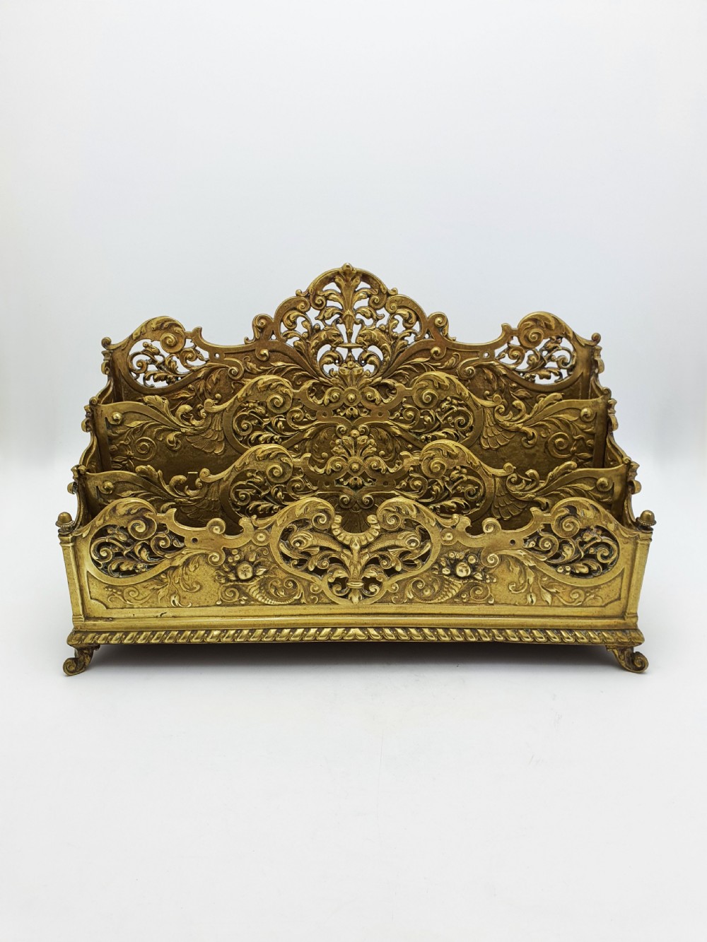 A cast brass Rococo Revival letter rack featuring three tiered compartments with intricate pierced scrollwork and foliate cresting. View II