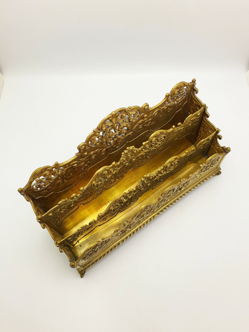 A cast brass Rococo Revival letter rack featuring three tiered compartments with intricate pierced scrollwork and foliate cresting. View III