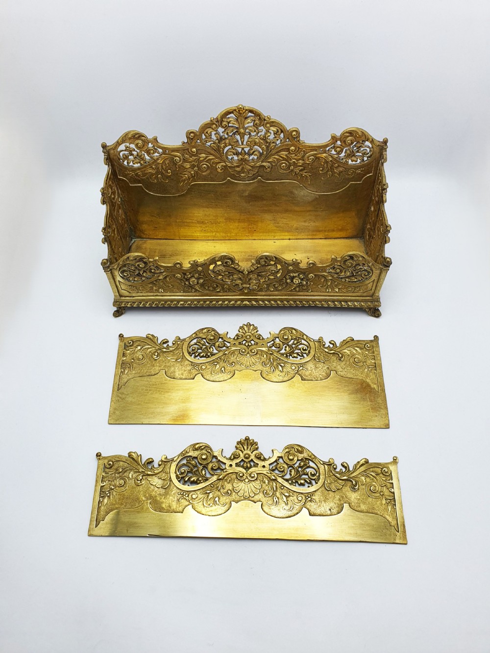 A cast brass Rococo Revival letter rack featuring three tiered compartments with intricate pierced scrollwork and foliate cresting. View X