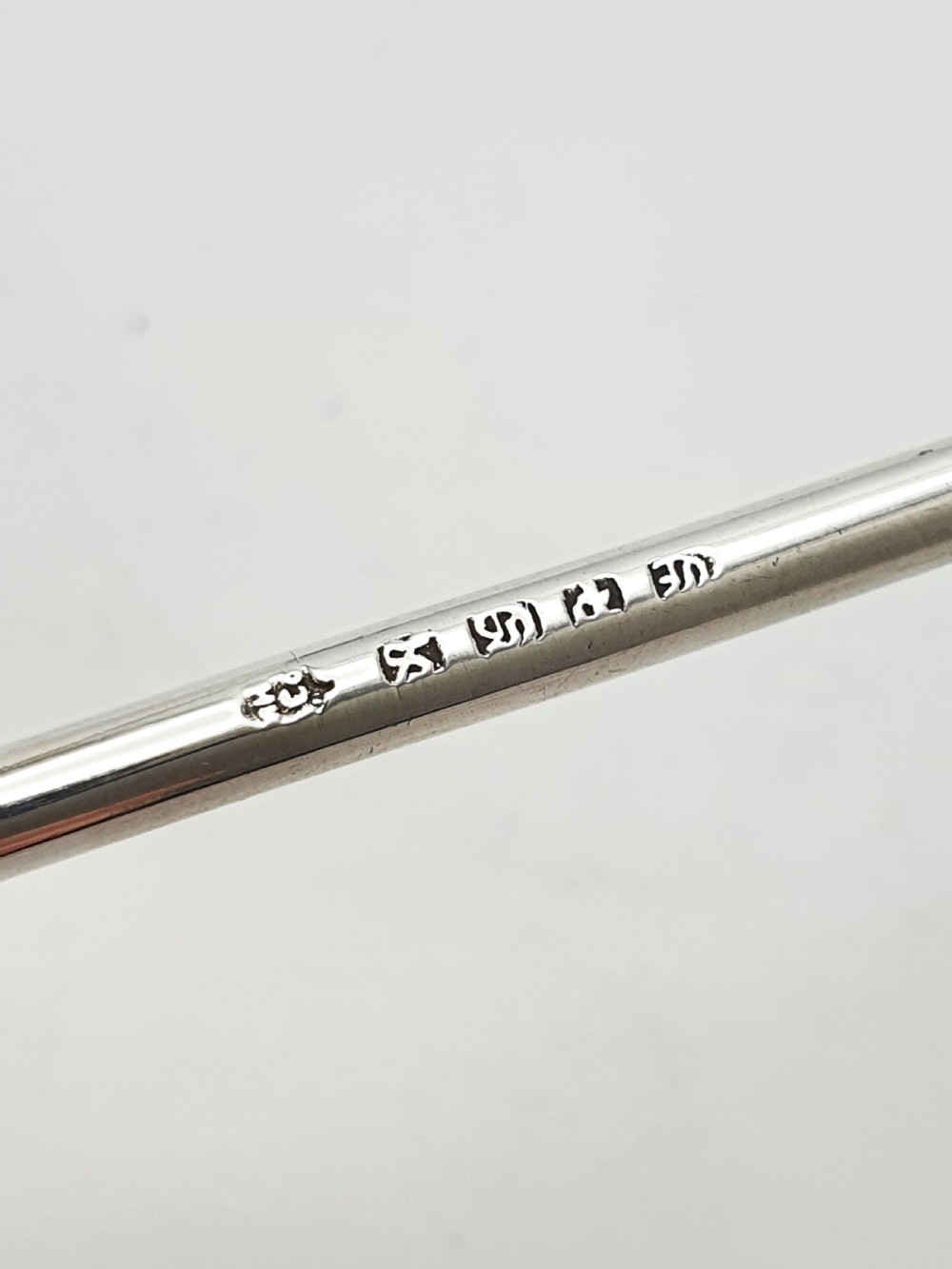 A late Victorian sterling silver receipt hook featuring a square stepped plinth base with beaded detail and a upright hooked stem. View VII