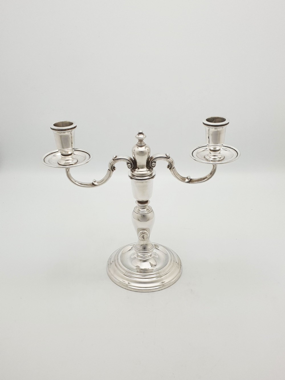 A pair of silver-plated low two-branch candelabra featuring turned central stems, circular stepped bases, and scrolled arms. View II